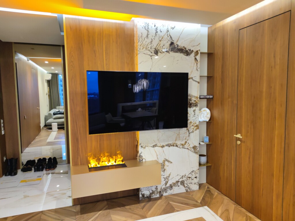 Камін і телевізор у перегородці між передпокоєм і вітальнею DreamHouse.