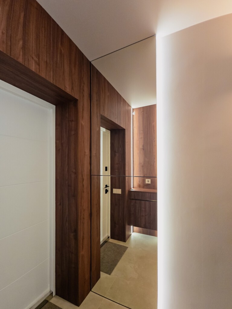 Панелі під горіх і білі міжкімнатні двері в коридорі DreamHouse.