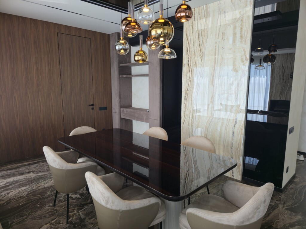 Обідній стіл біля дзеркальної панелі в чорній рамі DreamHouse.